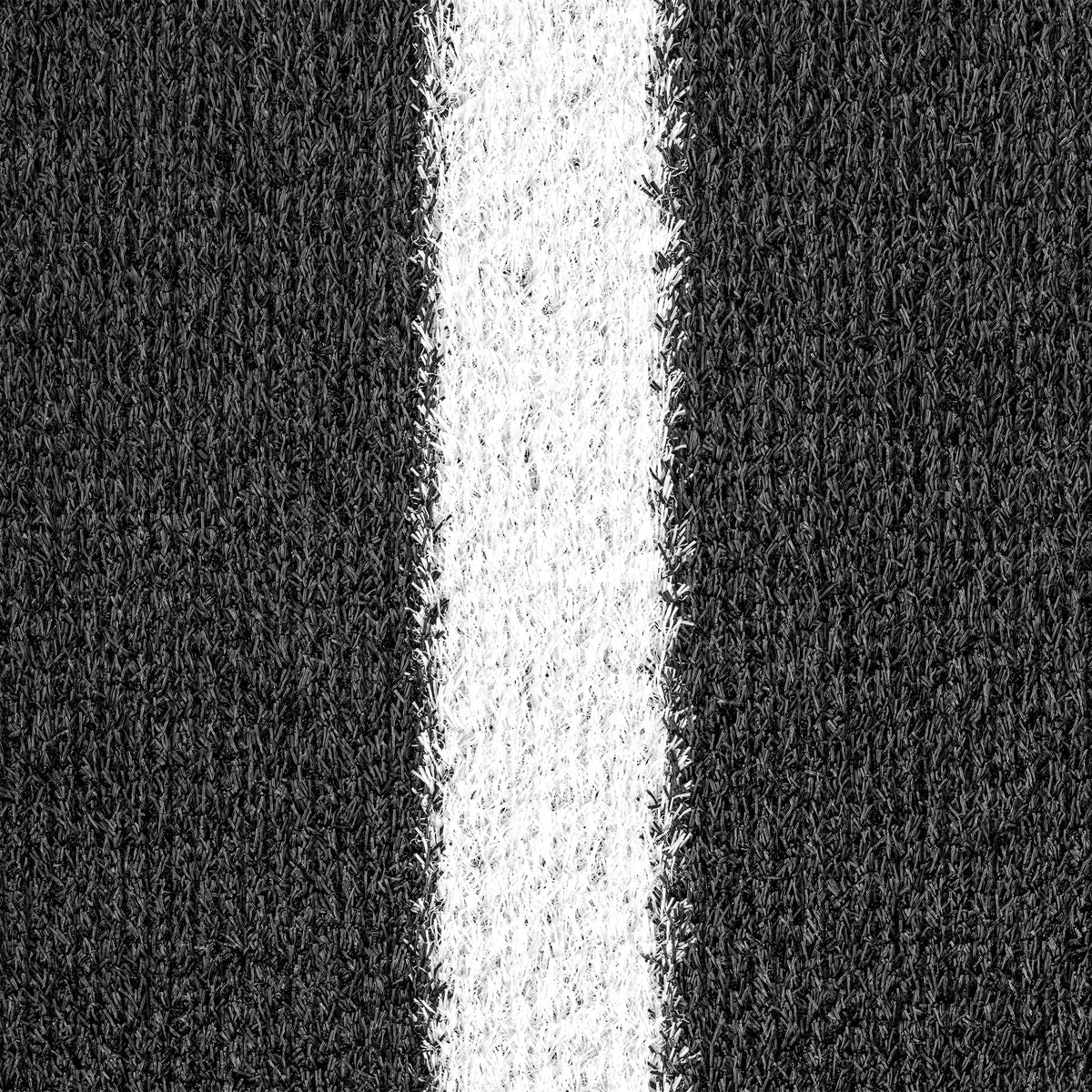 Pormenor dos filamentos pretos e da linha branca da relva artificial GRASS-BLACK para treino funcional e sled push.